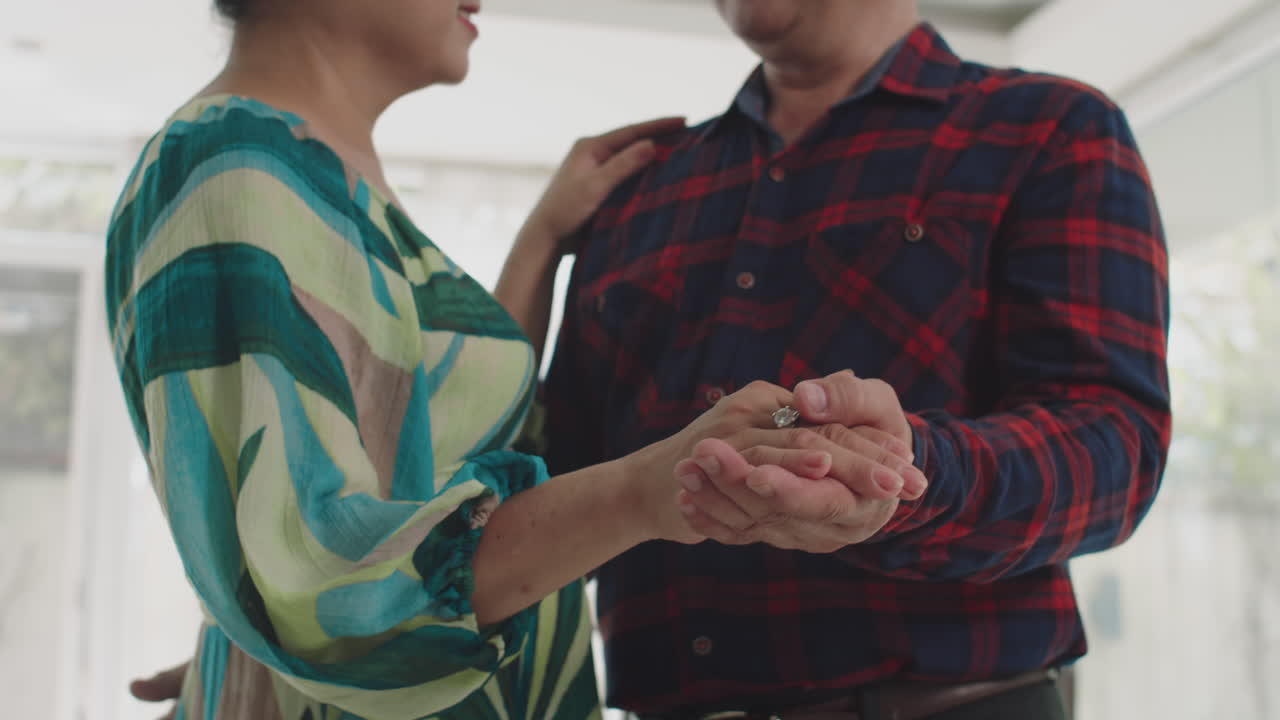 Spouses Holding Hands Together while Dancing