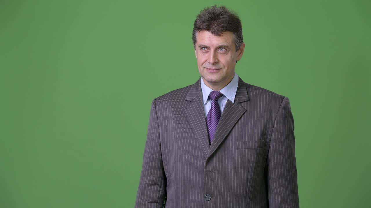 Uomo d'affari maturo e affascinante su sfondo verde