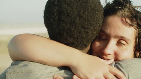 happy young woman in wheelchair hugging her male friend outdoors