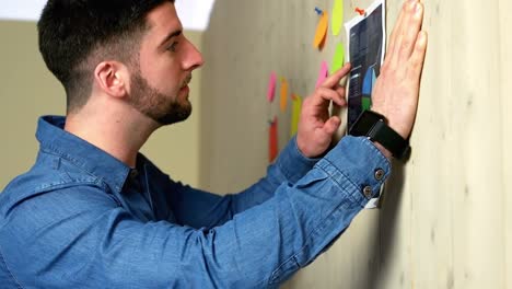 business executive reading notices on notice board