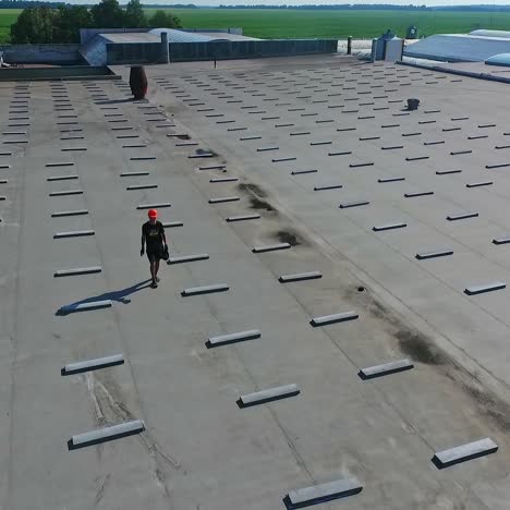 building the solar farm on flat roof. flying over the construction site of future alternative power plant on the top of building. aerial view.