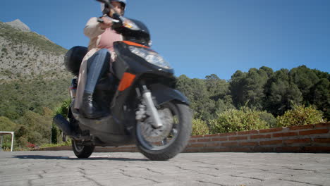 Woman-starting-her-scooter-and-driving-away-in-slow-motion