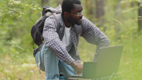 ecologist working on laptop in forest