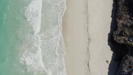 Top-down-of-Sunbather-laying-on-Tecolote-Beach,-Baja,-Mexico