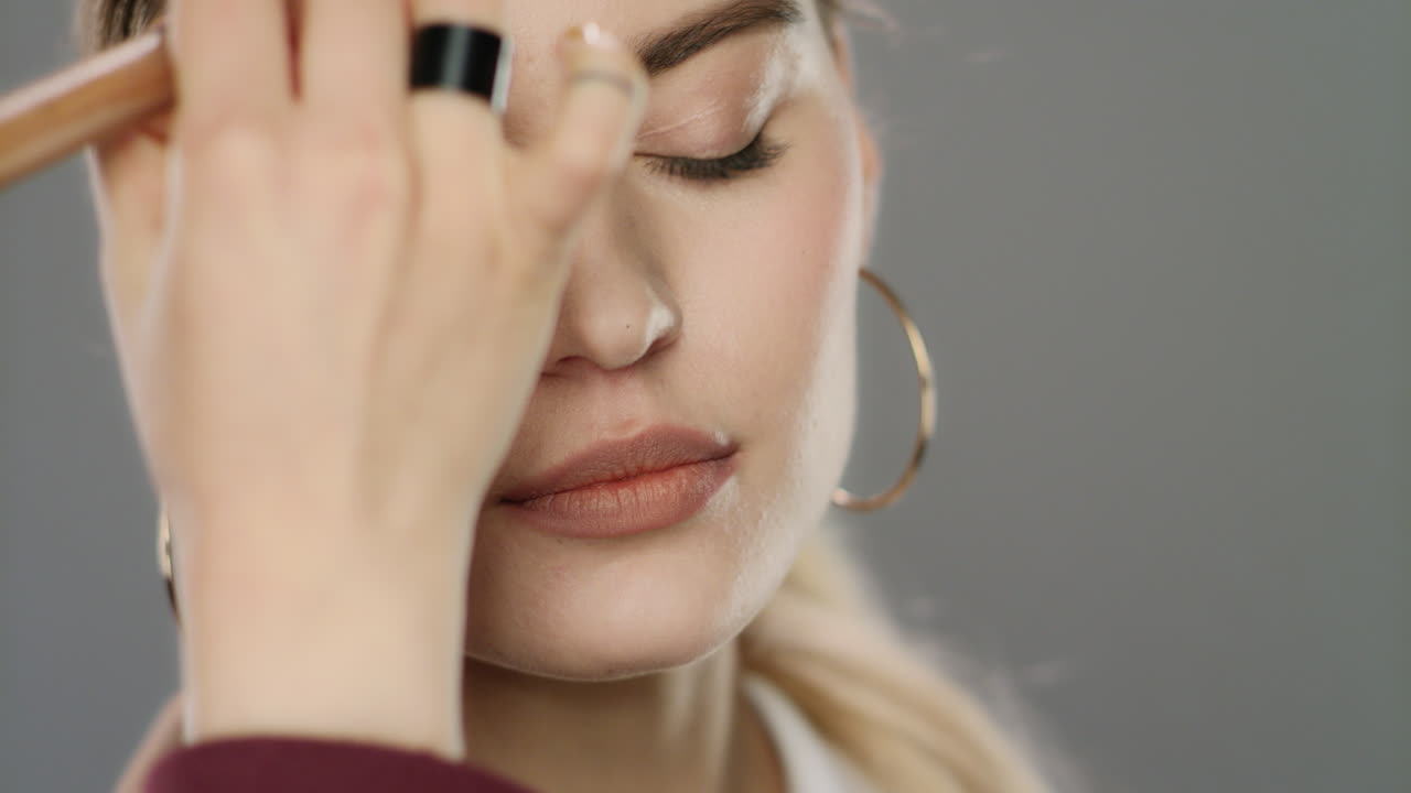 cara de modelo de moda con pincel de maquillaje en el estudio. mujer joven cara de maquillaje