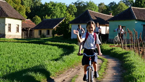 children riding bicycles on a rural path to school