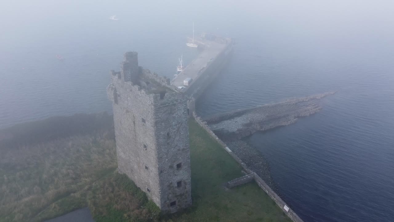castillo de carrigaholt y puerto pesquero en una niebla de verano
