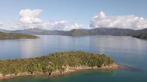 flying above an overgrown peninsula in the marlborough sounds and towards coastal mountains