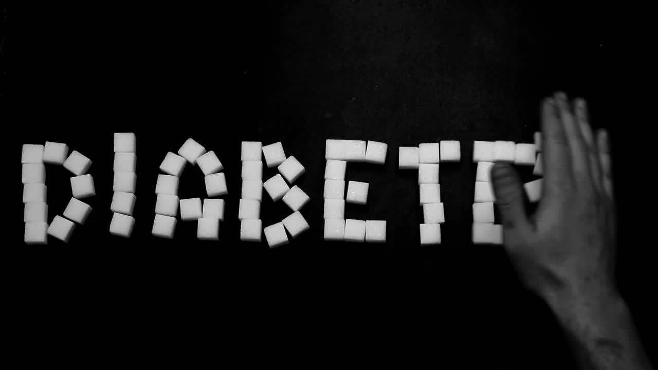 Mano che allontana il diabete scritto con cubetti di zucchero