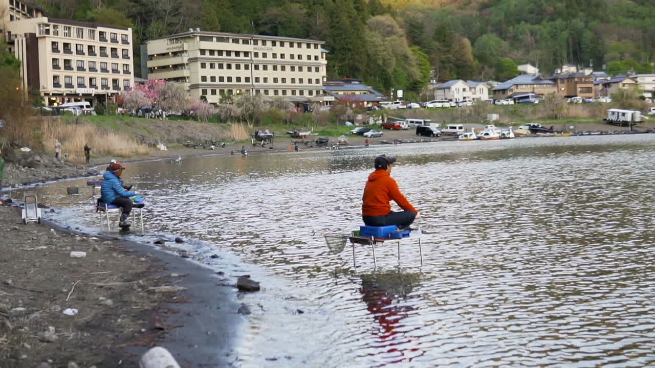 Wide shot of some fishermen at Lake Kawaguchiko, Japan