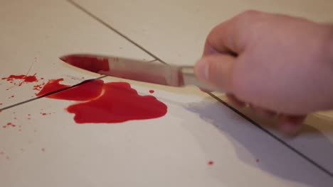 Lifting-a-murder-weapon-knife-splattered-with-blood,-closeup