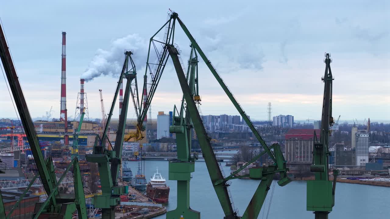 Aerial shot over Gdansk Shipyard showing cranes, ships, and a coal heat plant