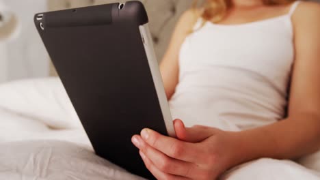 Frau-Benutzt-Digitales-Tablet-Im-Bett