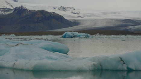 glacier lagoon, jökulsárlón, iceland, with icebergs and flowing icy blue water