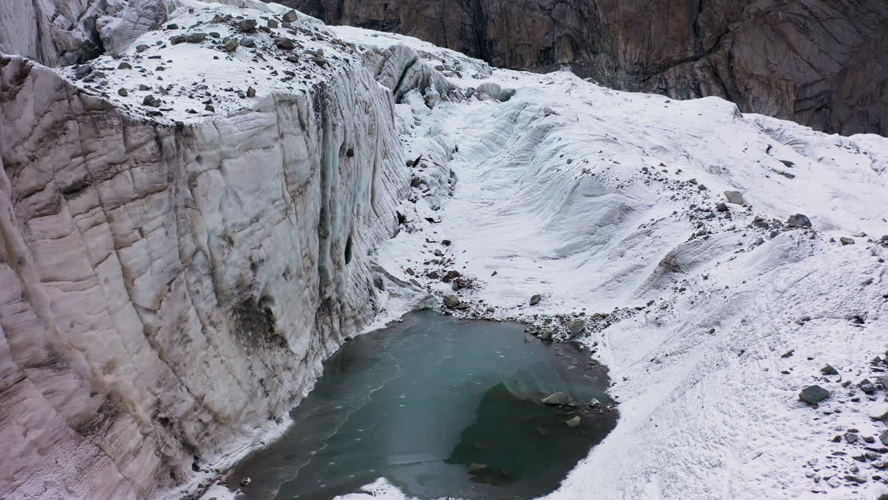 toma cinematográfica de un barranco y un pequeño lago en el glaciar ak-sai en kirguistán