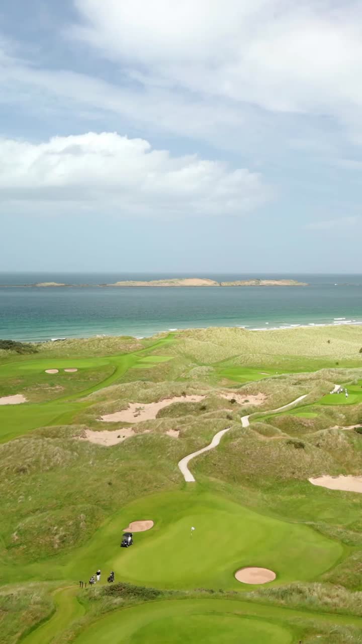 Slow overhead social ratio aerial video of Royal Portrush Golf Course in County Antrim, Northern Ireland, UK on a sunny day. Produced in 1080x1920 vertical ratio, 60FPS and with Rec709 color
