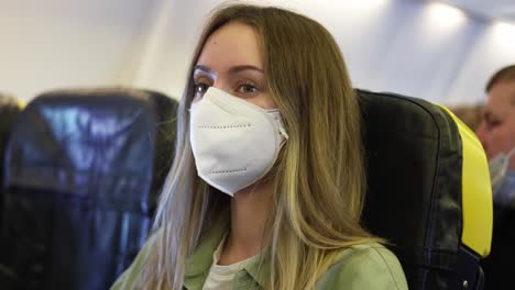 mujer rubia con respirador blanco dentro del avión