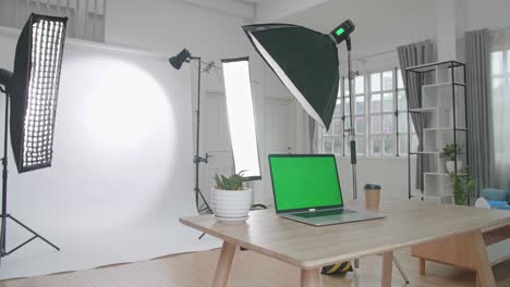 photo studio with professional equipment and green screen laptop computer display