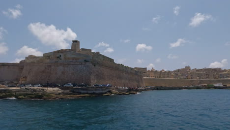 boat tour off the coast of malta, valletta overlooking pier with historical building