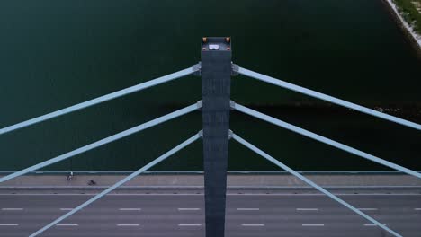drone camera shifting down from a beautiful river scenario onto passing cars on a important bridge in germany