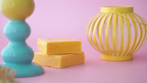 Yellow Bars of Soap with Decorative Objects on Pink Background