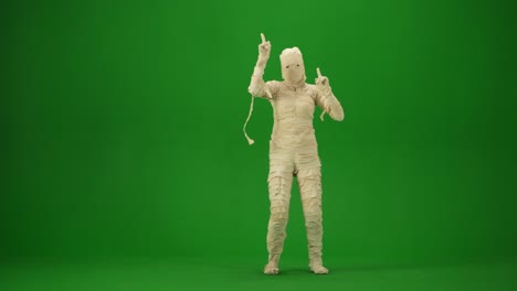 scary mummy wrapped in bandages dances wearing a black hat and sunglasses green screen isolated