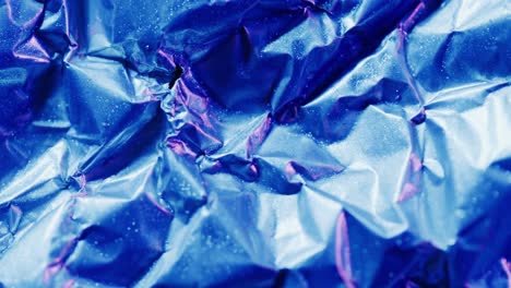 close up of blue crumpled piece of paper in slow motion