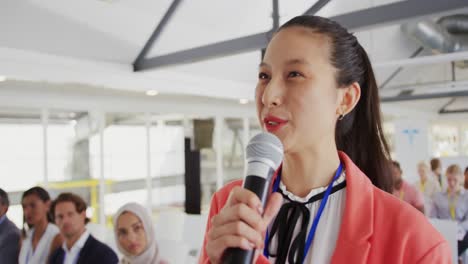 female audience member at a business conference asking a question