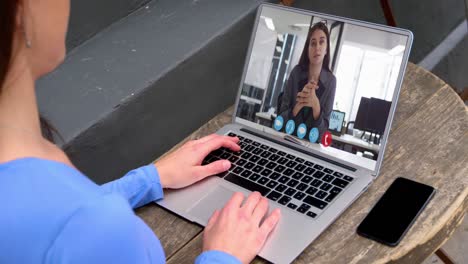 Caucasian-businesswoman-sitting-at-desk-using-laptop-having-video-call-with-female-colleague