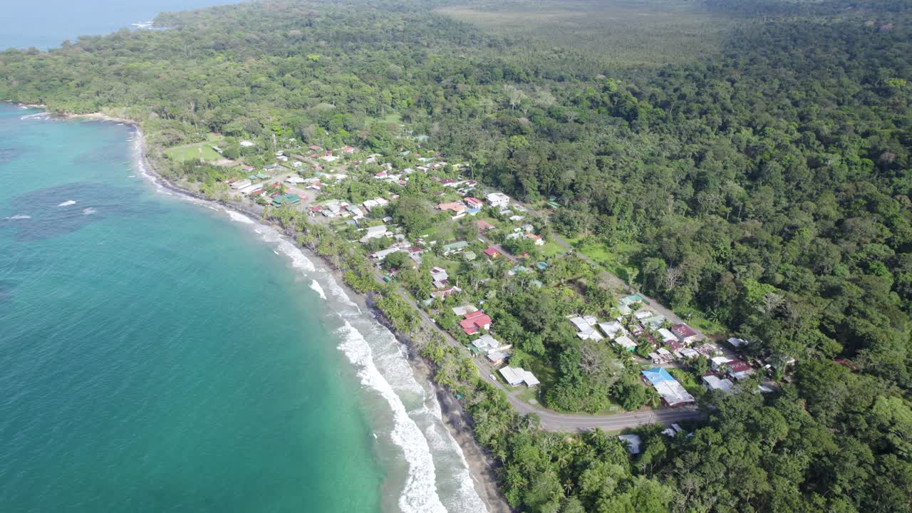 la costa de puerto viejo en costa rica, la exuberante vegetación y las aguas azules se encuentran con la pequeña ciudad de manzanillo, vista aérea