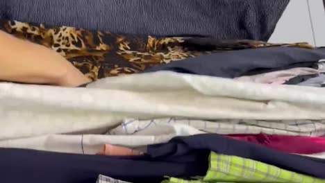 a woman chooses clothes in a secondhand store buying used clothes a woman chooses clothes in a secondhand store buying used clothes shooting medium plan