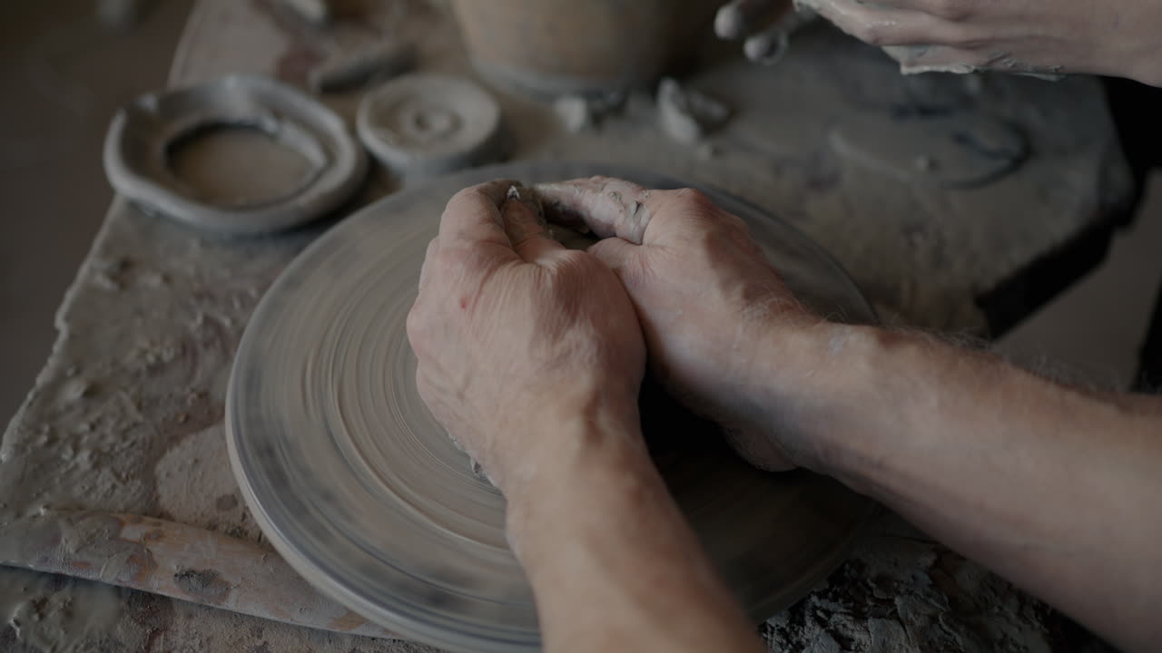 manos moldeando arcilla en una rueda de cerámica