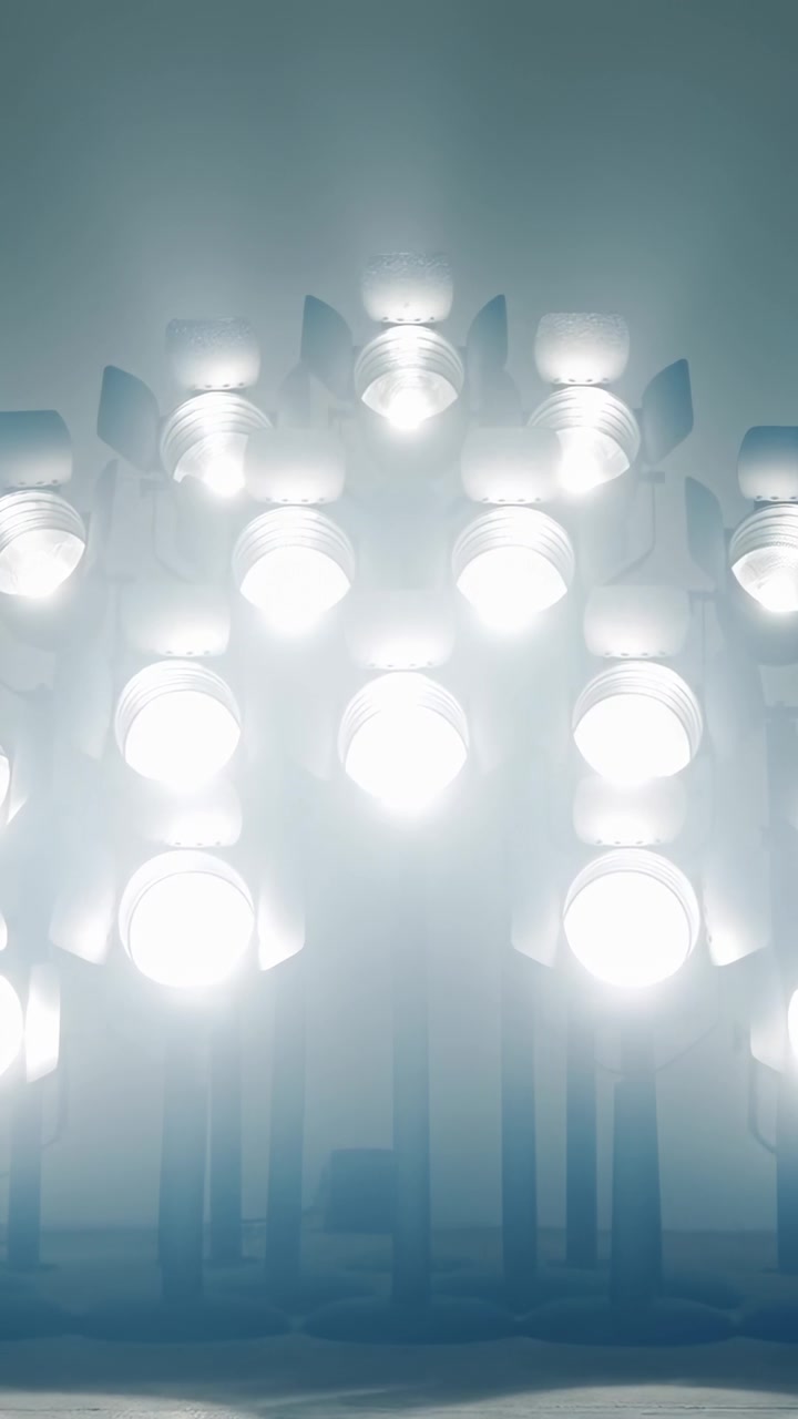 Vertical video: Starting with clustered lamp modules emitting cool light on pale wall for lighting
