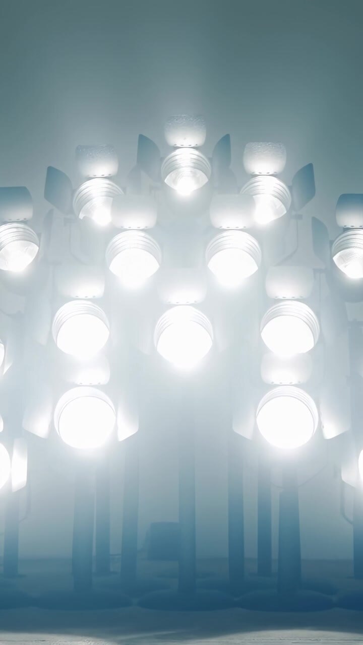 Vertical video: Starting with clustered lamp modules emitting cool light on pale wall for lighting