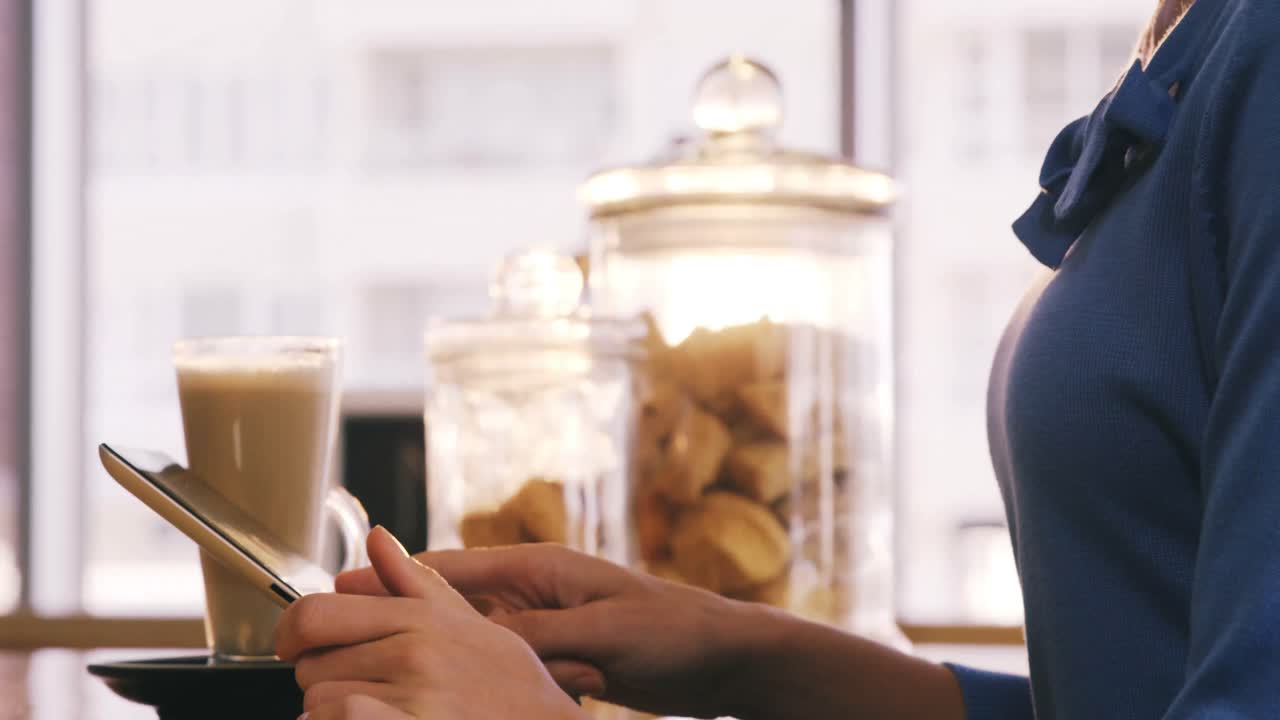Smiling woman using digital tablet in caf&Atilde;&copy;