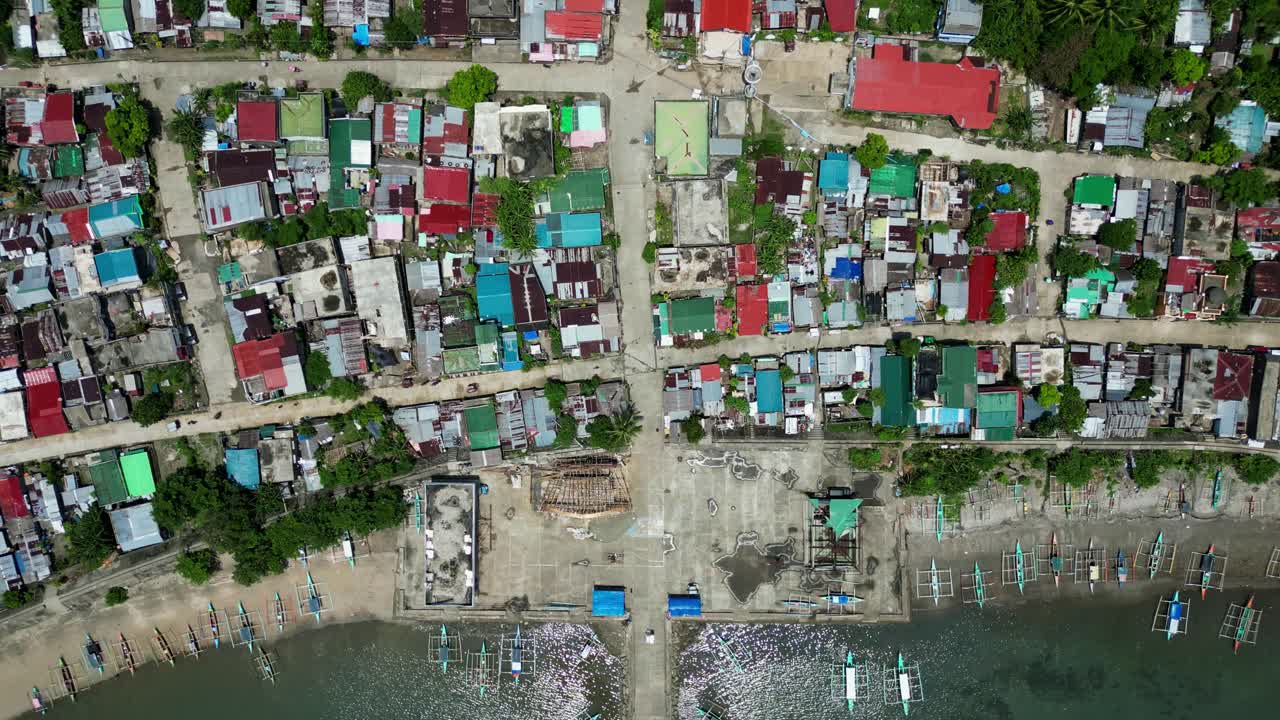 Aerial top-down view of colorful, dilapidated rooftops at a coastal barangay village community at Codon, San Andres, Catanduanes, Philippines
