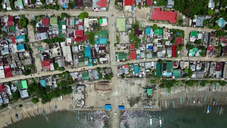 aerial top-down view of colorful, dilapidated rooftops at a coastal barangay village community at codon, san andres, catanduanes, philippines