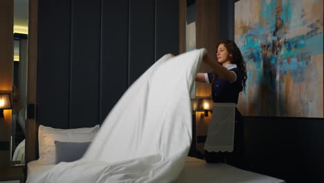 a maid making a bed in a hotel room