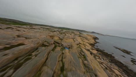 vuelo de avión no tripulado pasando bajo sobre la superficie rocosa de la costa de ramsvik en suecia