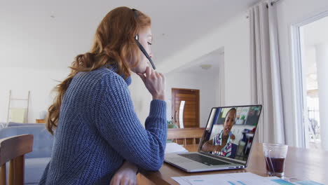maestra caucásica con auriculares de teléfono haciendo una videollamada con una chica en una computadora portátil en casa