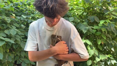 un adolescente con un conejillo de indias