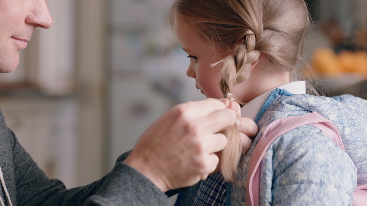 padre che prepara la figlia per la scuola che intreccia i capelli delle bambine che si diverte a prendersi cura del bambino