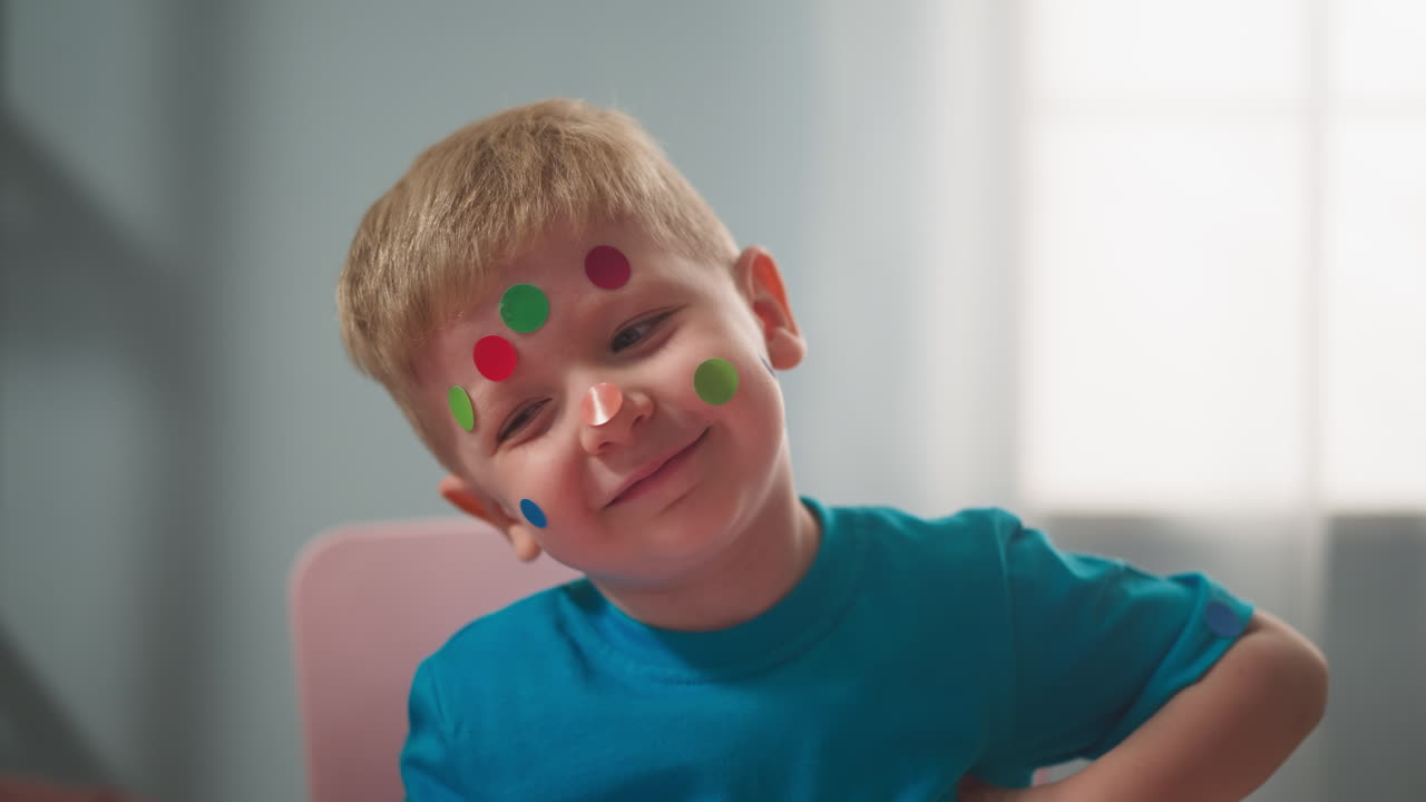 niño alegre con pegatinas de varios colores en forma de círculo