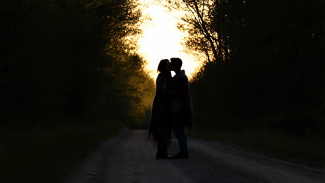 romantic couple silhouette on a road at sunset