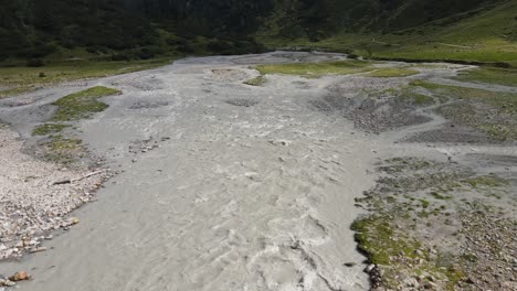 wide angle drone video of the beautiful mountains in northern italy with a giant waterfall and river. near the dolomites in south tyrol