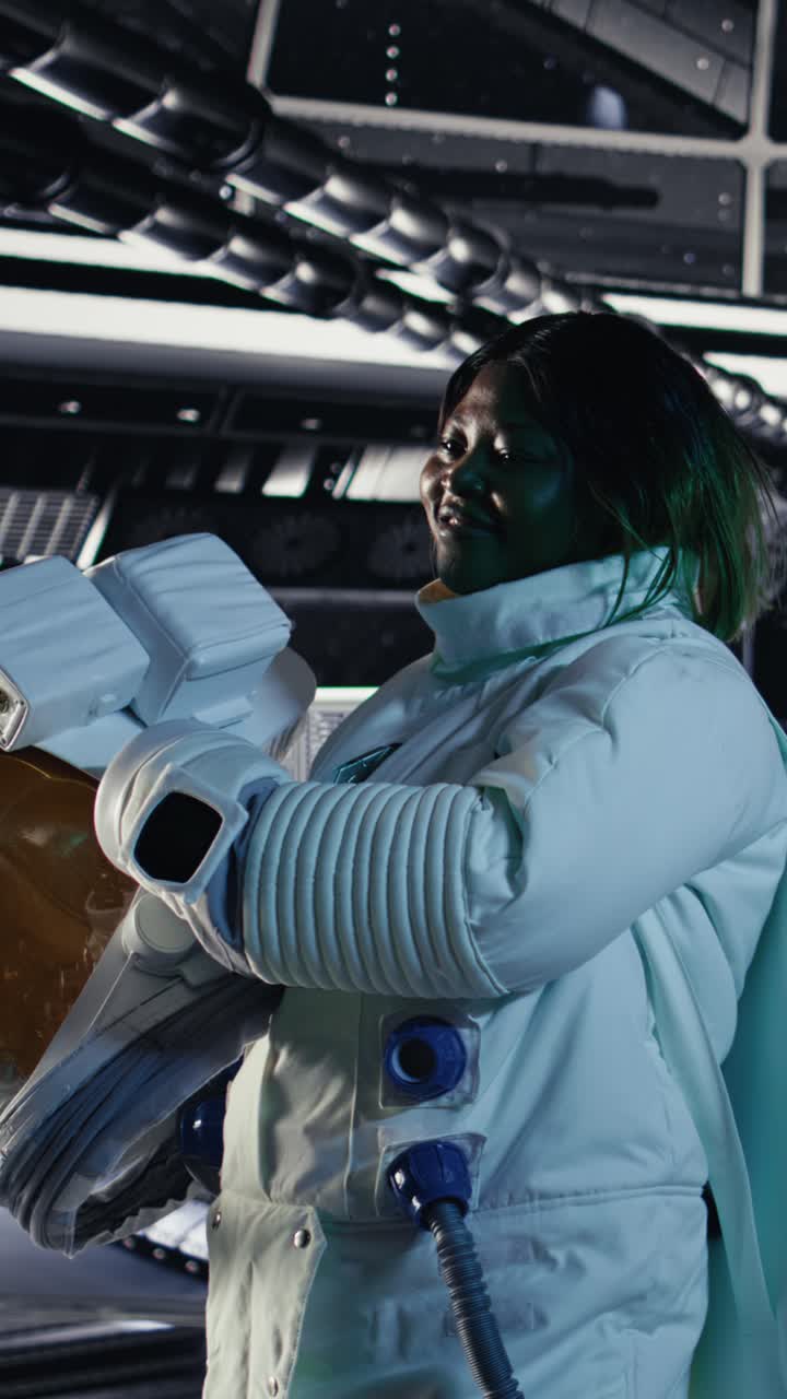 Vertical video Portrait of happy astronaut holding helmet in space station completing mission