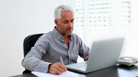 Casual-Geschäftsmann-Arbeitet-Am-Laptop-Am-Schreibtisch