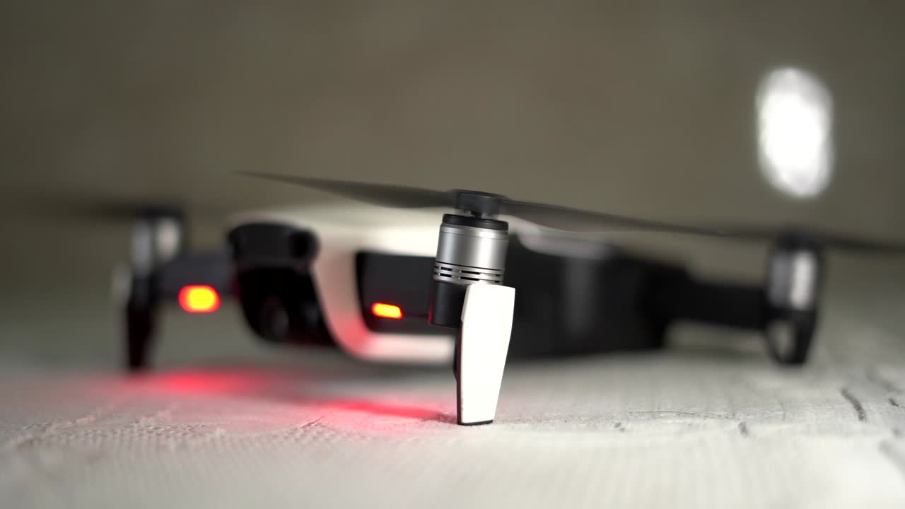 drone mavid air dji propulsor girando y deteniéndose en cámara lenta vista lateral