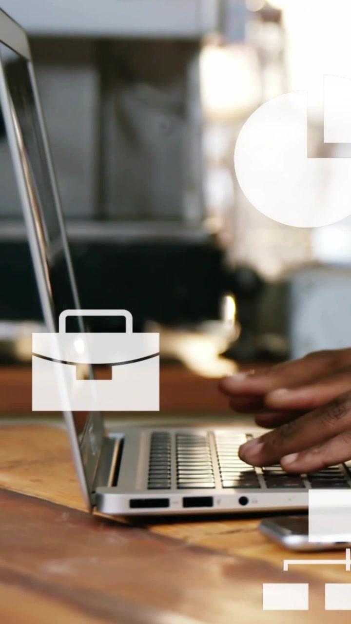 Vertical video: Hand entering typist typing on laptop for business icons and charts moving by phone