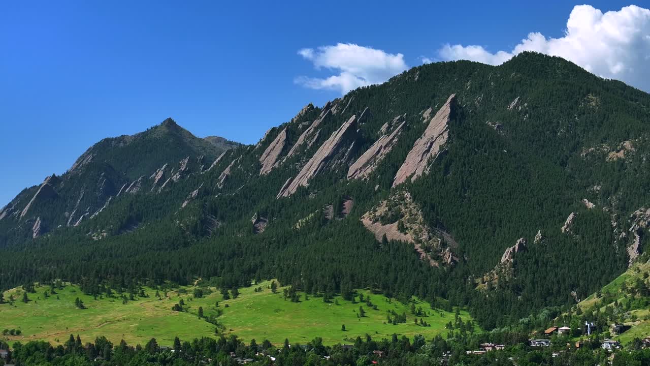 University city town of Boulder Colorado Pearl Street Mall Flatirons slanted Rocky Mountains aerial drone forward pan Chautauqua Park Boulder Creek Canyon Mountain Park hiking trails summer blue sky